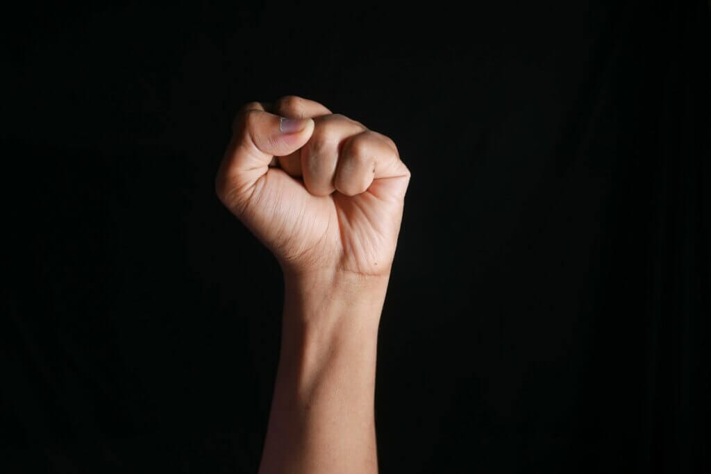 persons right hand doing fist gesture
